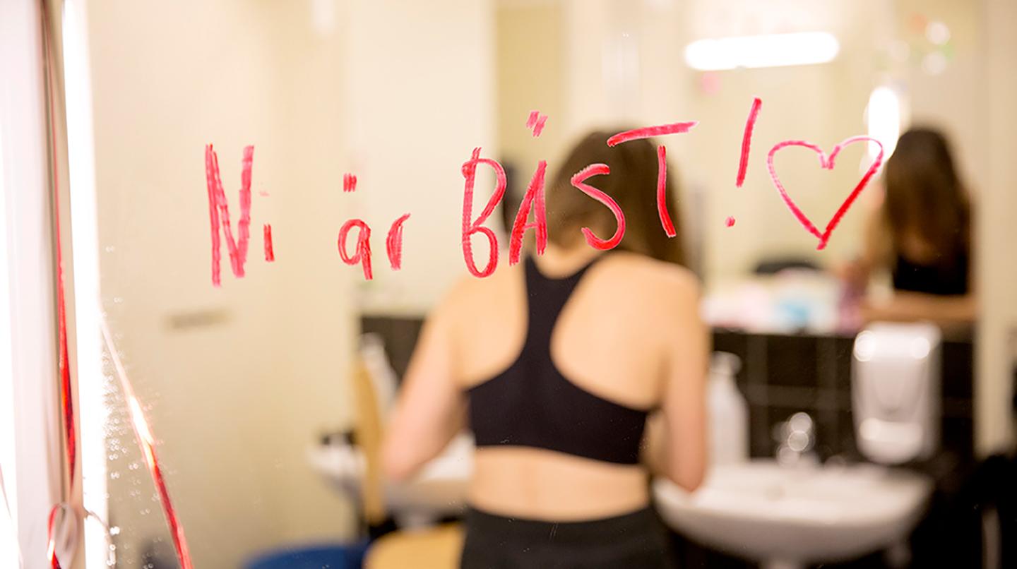 En loge-spegel där någon skrivit "Ni är bäst!" med ett läppstift. 