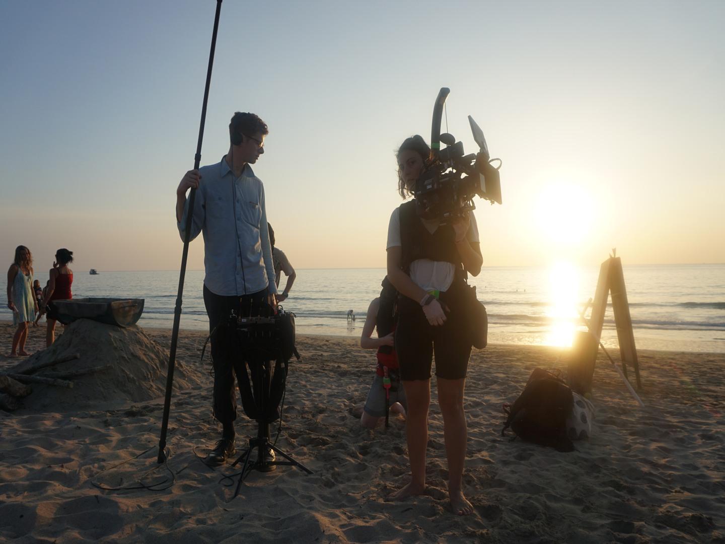 Ett filmteam jobbar på en sandstrand i solnedgång. Från arbetet med examensfilmen Banana Pancake Trail, 2018.