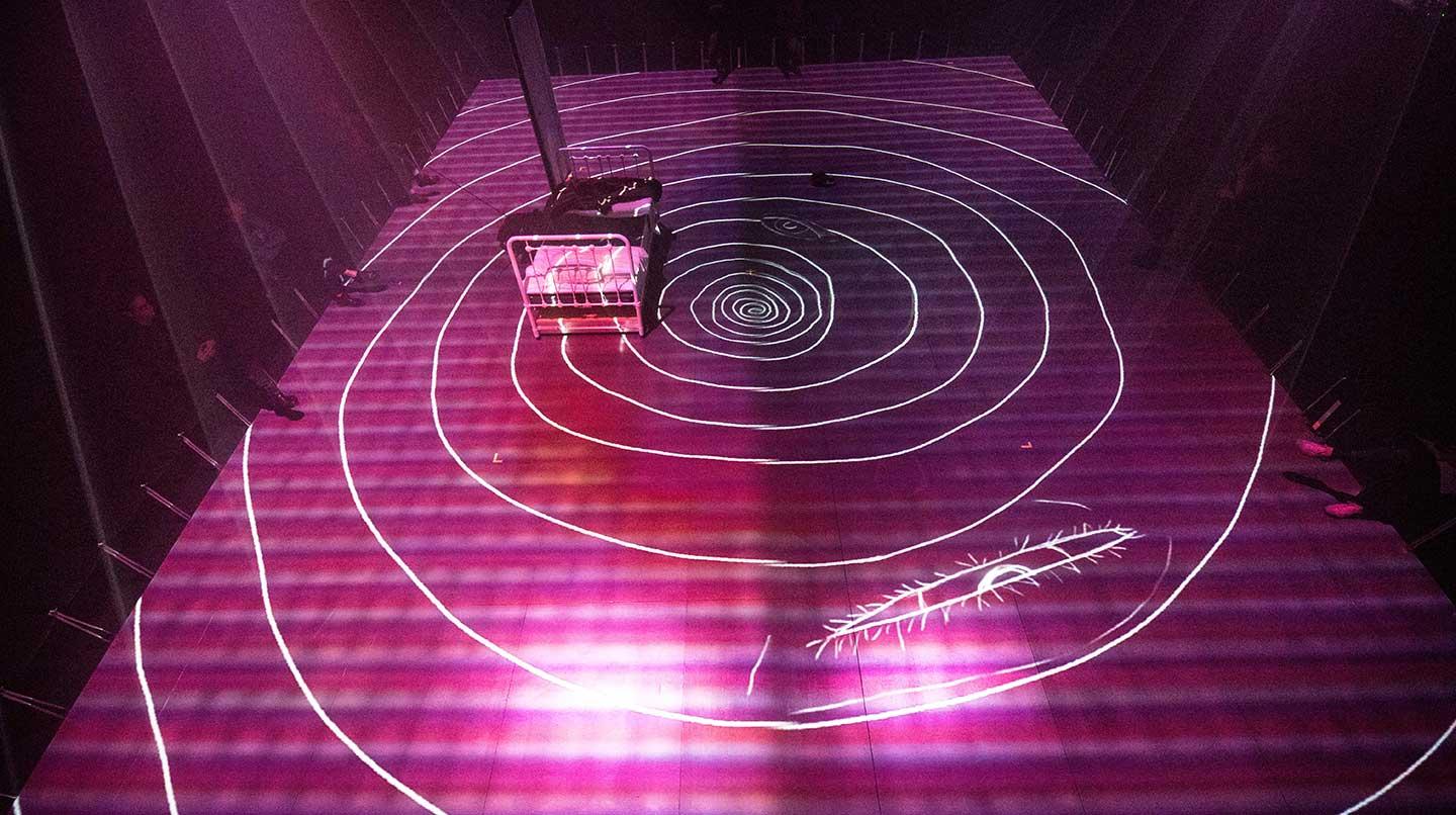Ljusprojektion på ett studiogolv i lila, från scenkonstövningen Efemär gestaltning, 2017.