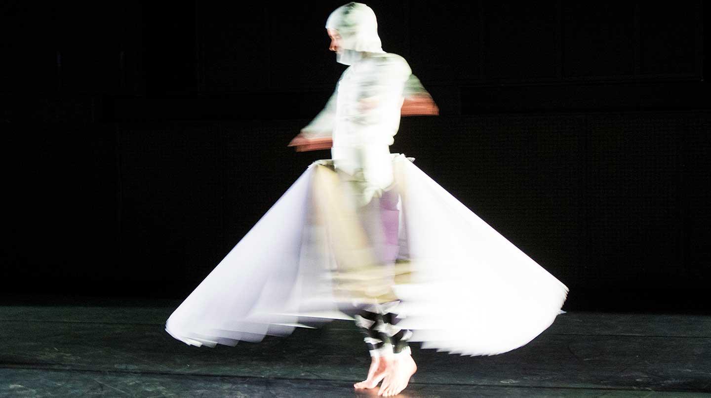 A spinning mime student with a wide skirt from the Costume in Transformation course.