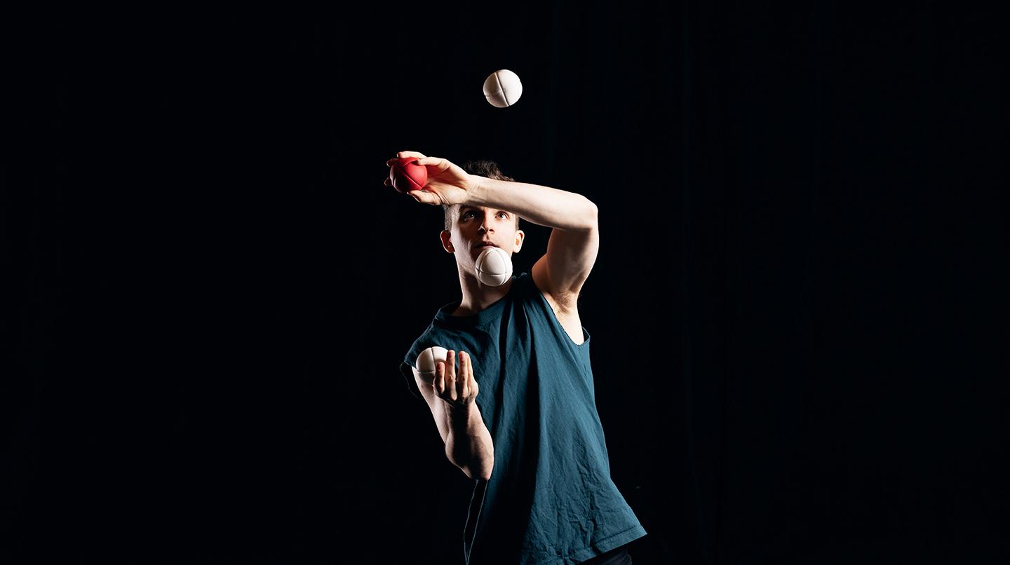 En kille jonglerar med tre bollar. Från cirkusföreställningen Closing Acts 2022.