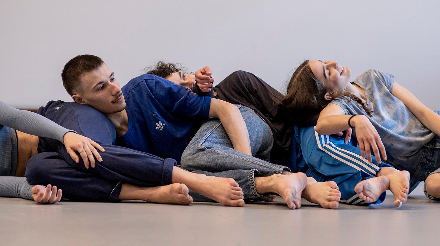 Dansstudenter ligger på varandra som dominobrickor. Från föreställningen Dance Empathy 2022.